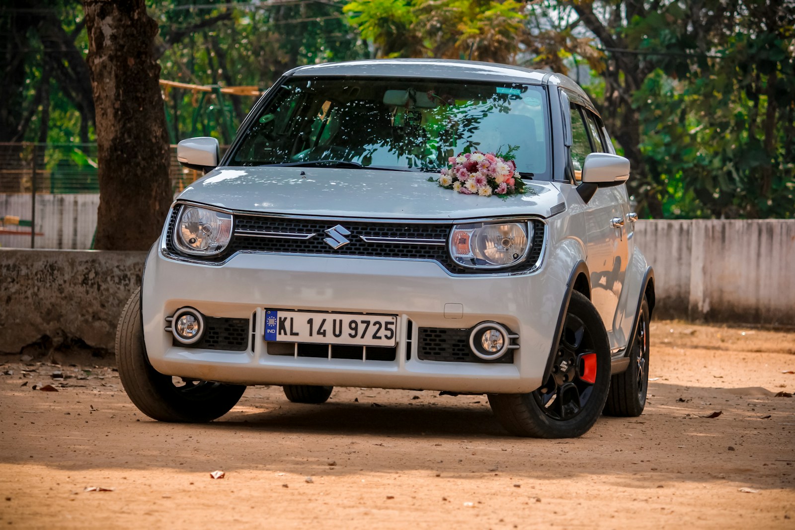 a small white car parked on a dirt road