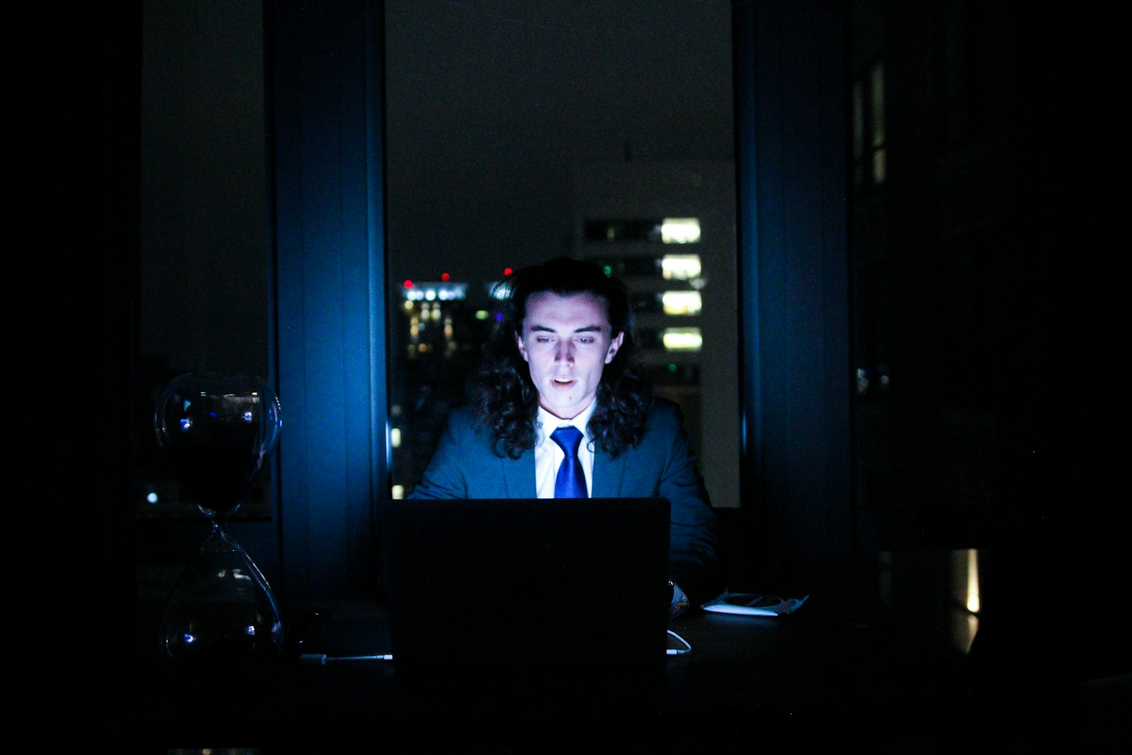 man using computer in dark room
